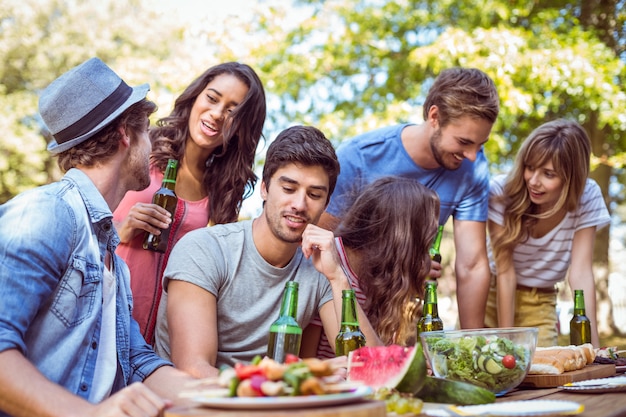 Felizes amigos no parque almoçando