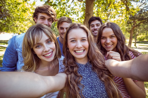 Felizes amigos no parque tomando selfie