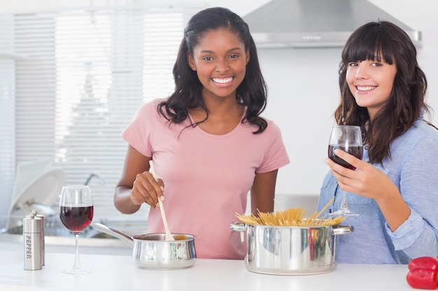 Felizes amigos preparando o jantar juntos