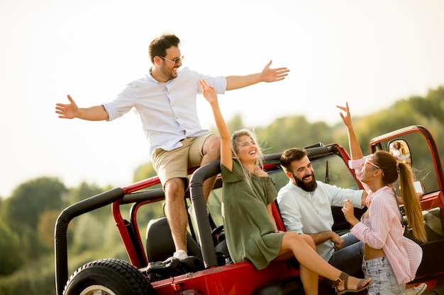 Felizes amigos se divertindo no carro conversível em férias