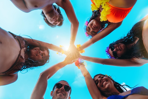 Felizes amigos sorridentes se cumprimentam na piscina