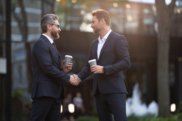 Felizes dois parceiros de negócios negociando dois parceiros de negócios negociando ao ar livre