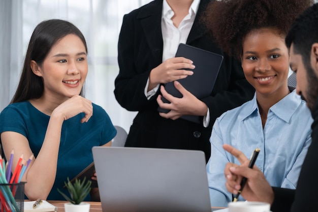 Felizes empresários diversos trabalham juntos discutindo no escritório corporativo O trabalho em equipe profissional e de diversidade discute o plano de negócios na mesa com o laptop Trabalhador de escritório multicultural moderno Concord