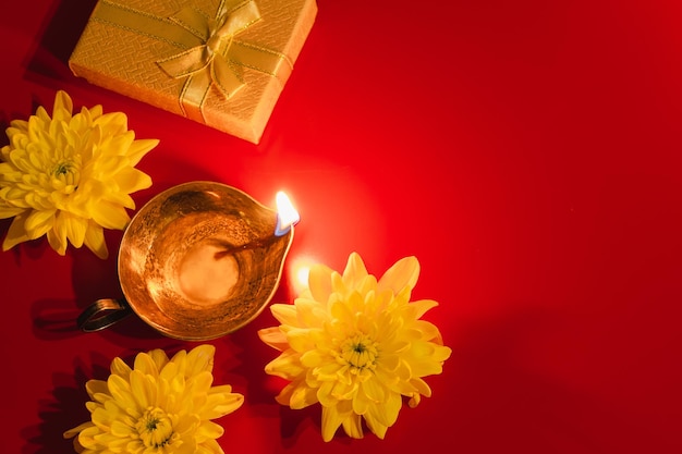 Felizes flores de lâmpada de óleo Diwali Diya e caixas de presentes em fundo vermelho Celebrando o tradicional festival indiano de luz