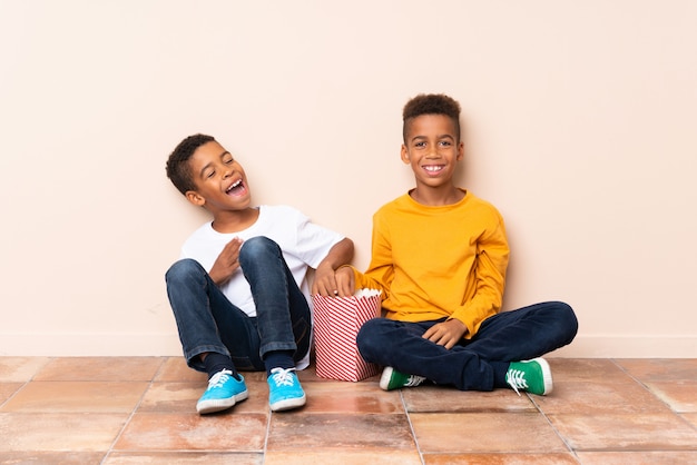 Felizes irmãos afro-americanos segurando pipocas