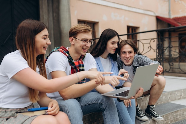 Felizes jovens estudantes estão conversando no campus