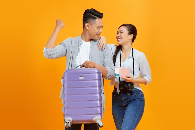 Felizes jovens turistas casal amigos homem mulher isolado em fundo amarelo