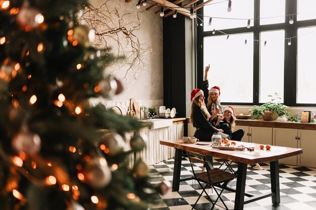 Foto felizes meninas engraçadas celebram as férias de natal e ano novo em uma casa aconchegante