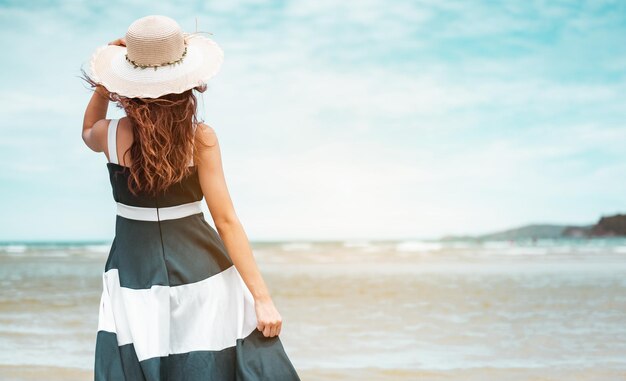 Felizes mulheres asiáticas com segurando o carrinho de chapéu para receber o vento e aproveitar a vida nas férias na praia. praia, verão, liftstyle, humor positivo, viagens, relaxe o conceito.