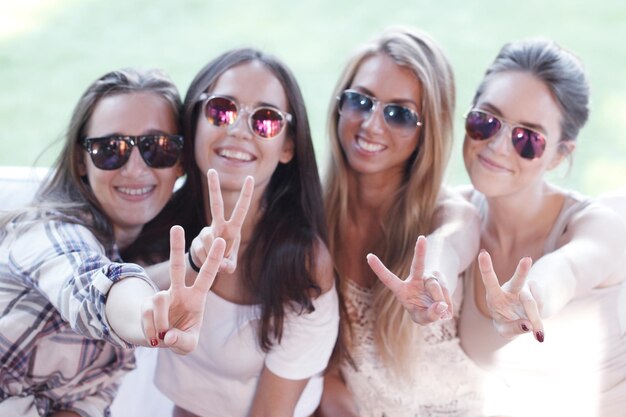 Felizes namoradas sorridentes mostrando sinal de mão av