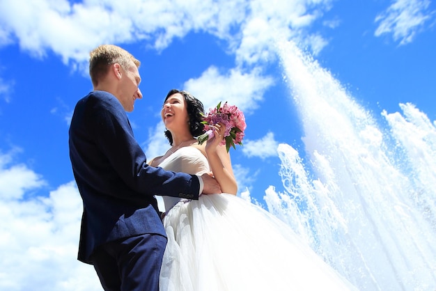 Felizes recém-casados no fundo do céu de verão