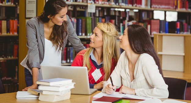 Felizes três estudantes trabalhando juntos