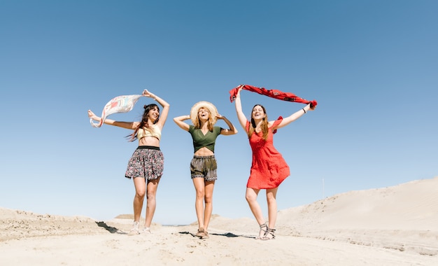 Felizes três mulheres se divertindo caminhando na praia. jovens em férias no verão desfrutam de liberdade