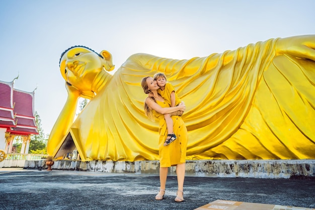 Felizes turistas mãe e filho no fundo da estátua de Buda Mentir