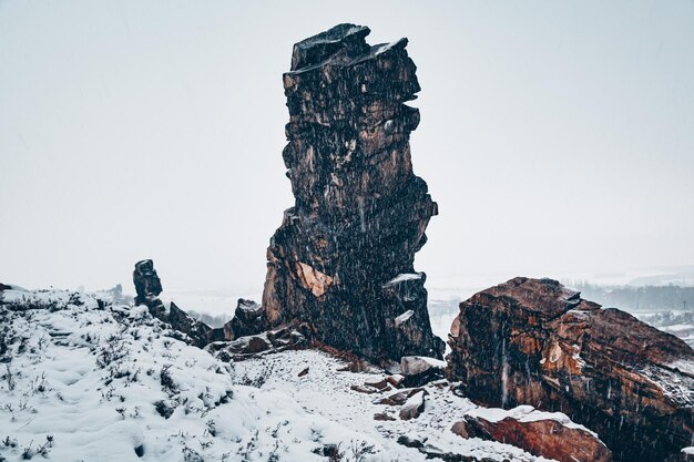 Felsbildung auf schneebedecktem Land gegen den Himmel