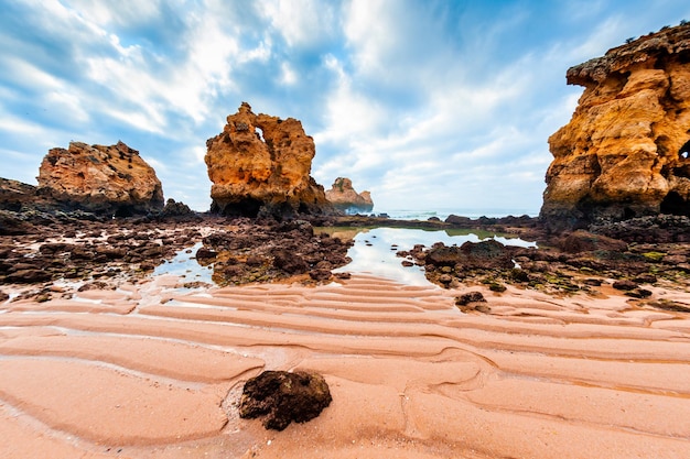 Felsen am Sandstrand in Algarve, Portugal. Küste des Atlantiks, Sommermeerblick