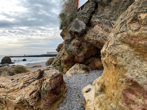 Felsen am Strand unter dramatischem grauem Himmel