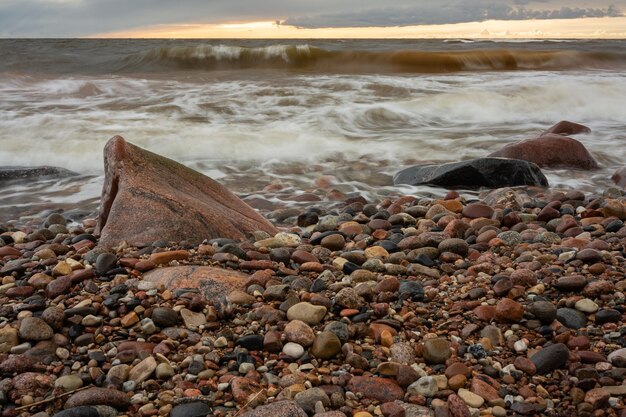 Foto felsen am ufer am strand bei sonnenuntergang