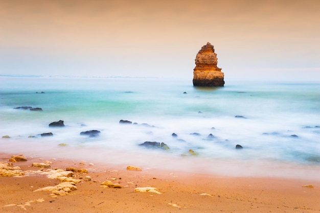 Felsen am Ufer des Atlantiks in Algarve, Portugal. Aufnahme mit langer Belichtungszeit. Schöne Meereslandschaft am nebligen Morgen