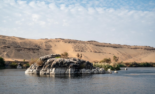 Felsen mitten im Nil mit der Wüste im Rücken Ägypten