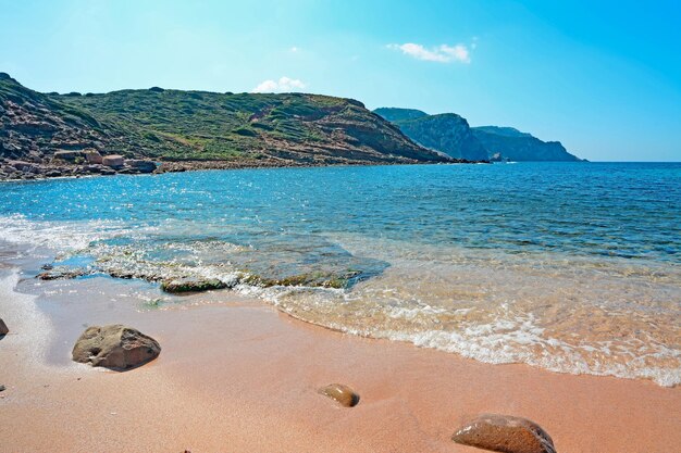 Felsen und Sand in einem rosafarbenen Strand