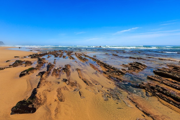 Felsformationen am Sandstrand (Algarve, Costa Vicentina, Portugal).