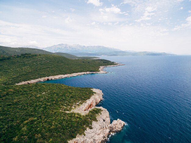 Felsige Küste in der Nähe von veslo camping in montenegro azurblaues wasser weiße wellen schlagen die felsen sonnig