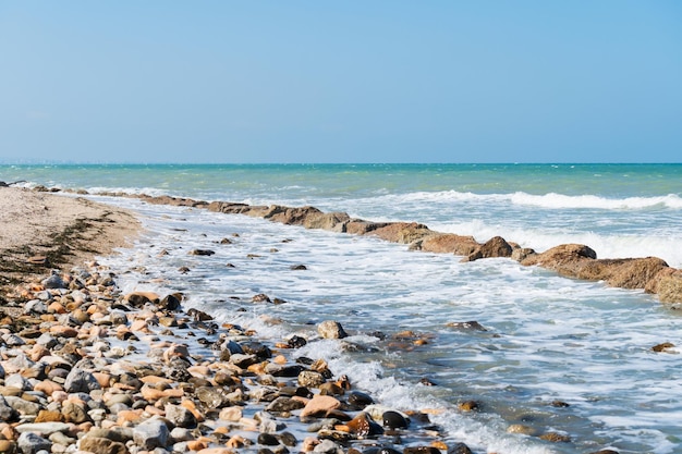 Felsige Küstenlinie, Meereswellenhintergrund, brechendes Meerwasser, felsige Küste, raues türkisfarbenes Wasser in Rimini