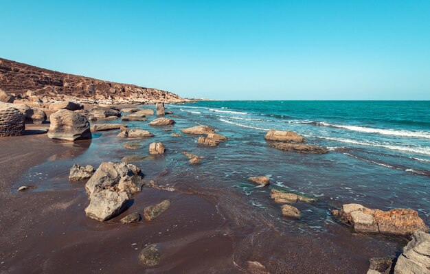 Felsige Meeresküste mit türkisfarbenem Wasser am Strand