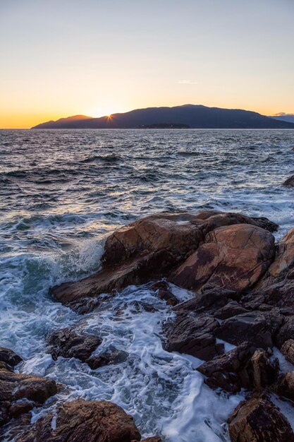 Felsige Ozeanküste während eines lebhaften sonnigen Sonnenuntergangs