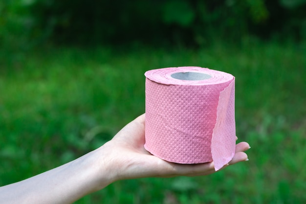 Female Hold Toilettenpapier übertreffen die Natur. Konzept von Durchfall in der Sommersaison