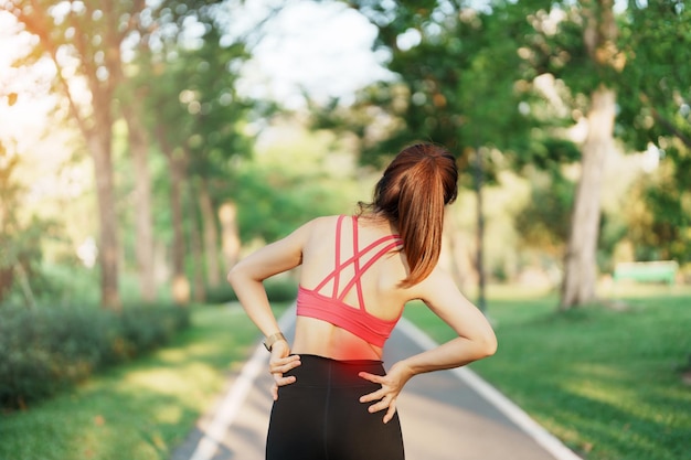 Fêmea adulta com dor muscular durante a corrida, corredora com dor nas costas e na cintura devido à síndrome do piriforme, dor lombar e compressão da coluna vertebral, lesões esportivas e conceito médico