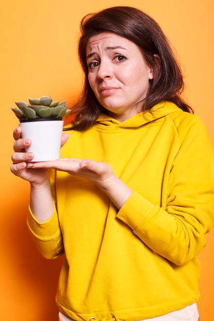 Fêmea amante de plantas segurando um vaso de flores