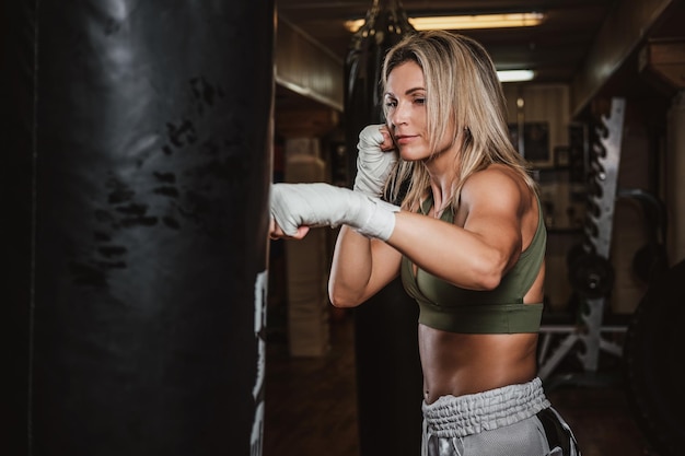 Fêmea boxer bonita tem seu treinamento com saco de pancadas no ginásio.