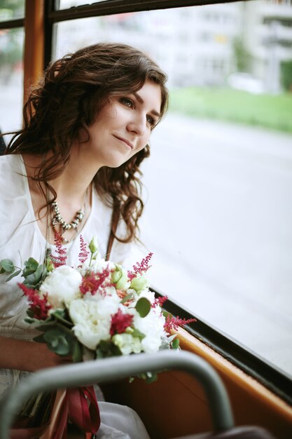 Fêmea jovem com flores, sentado perto da janela