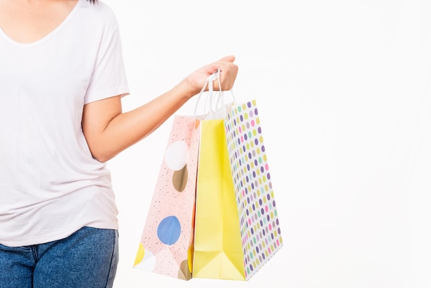 Fêmea segura na mão com saco de presente de papel ofício em branco vazio e multicolorido