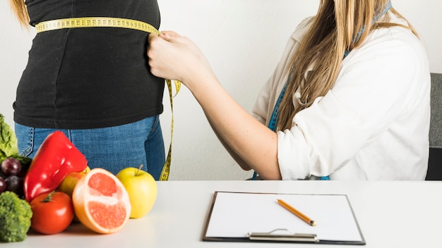 Foto femininas, dietician, examinando, paciente, em, clínica