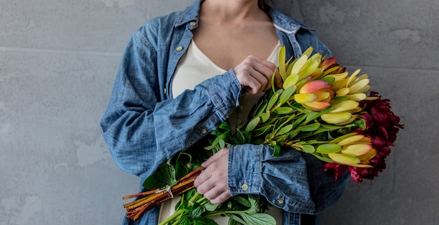 Femininas mãos segurando um buquê de peônias e Leucadendron