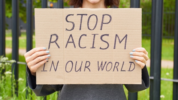 Femininas mãos segurando um cartaz sobre racismo