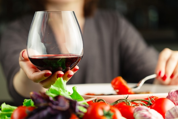 Feminino beber vinho tinto e comer frango roiast