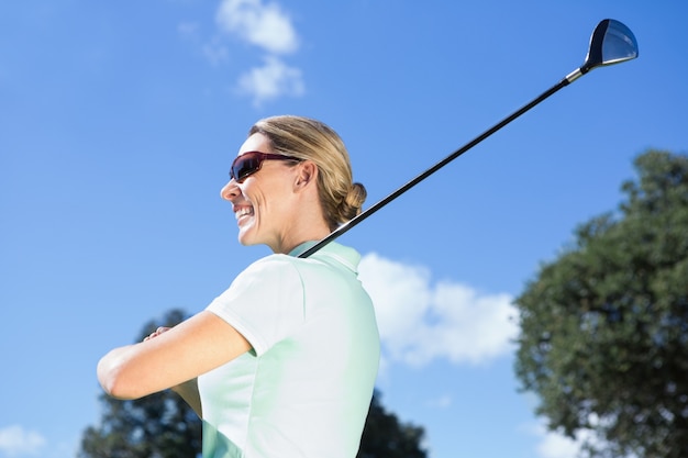 Feminino, golfista, ficar, segurando, clube, sorrizo