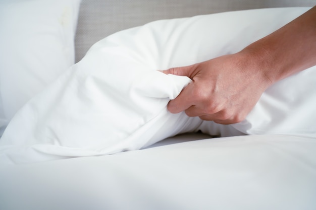 Feminino mão configurar lençol branco no quarto hotel