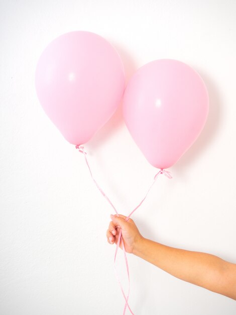 Feminino mão segurando balões rosa