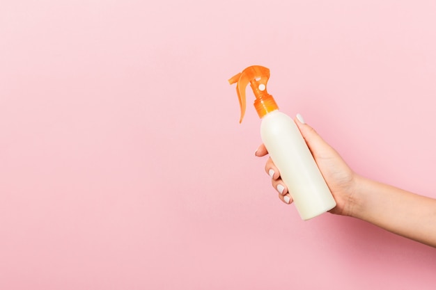 Feminino mão segurando o frasco de creme spray de loção