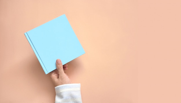 Feminino mão segurando o livro na cor de fundo