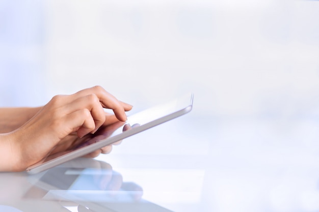 Feminino mão segurando o tablet digital de negócios, tocando a tela usando o computador