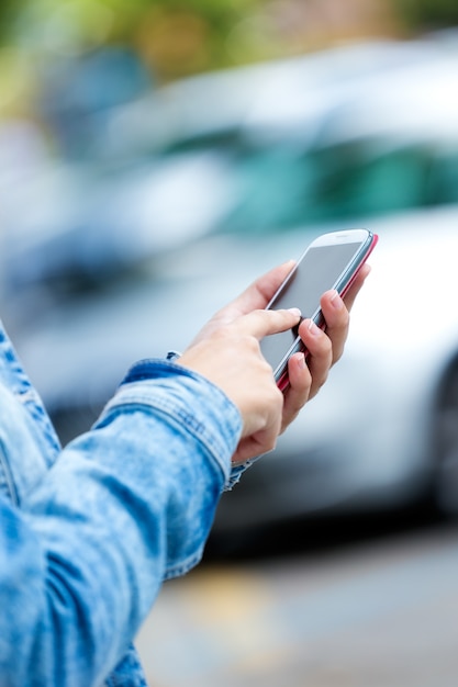 Foto feminino sem cara que usa o smartphone na rua