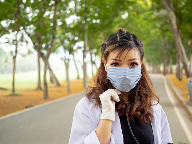 Feminino senhora pessoa enfermeira médico cientista usar uniforme luva máscara bonita bonita em pé olhar para a câmera estetoscópio jardim ao ar livre ambiente natural pesquisa médico saudável médico