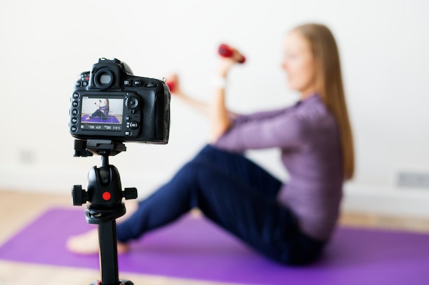 Feminino vlogger gravando esportes relacionadas com transmissão em casa