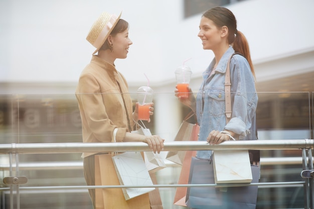 Femininos amigos conversando no shopping